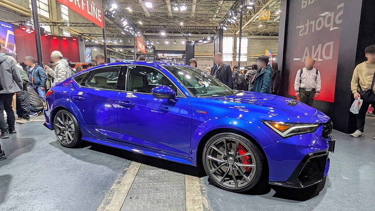 Side view of the Acura Integra Type S DE5 race car in World Blue, showing the widebody kit and aero