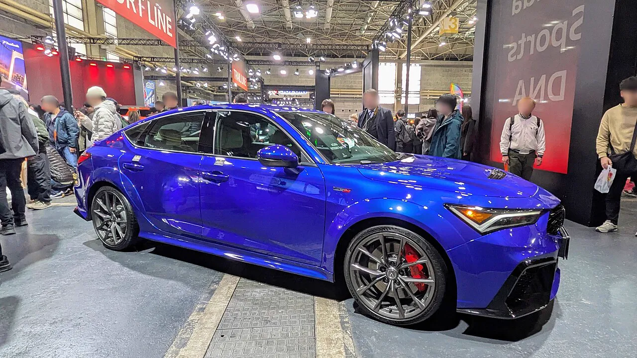 Side view of the Acura Integra Type S DE5 race car in World Blue, showing the widebody kit and aero