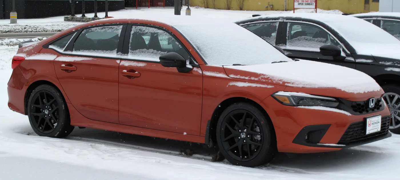 Honda Civic Si sedan in Blazing Orange Pearl, the manual-only Civic trim built at Honda of Canada Manufacturing in Alliston, Ontario