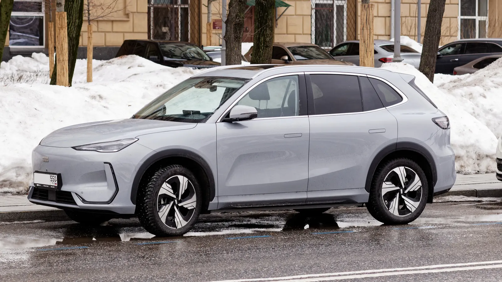 Geely EX5 compact electric SUV in light grey parked on a snowy street in Moscow