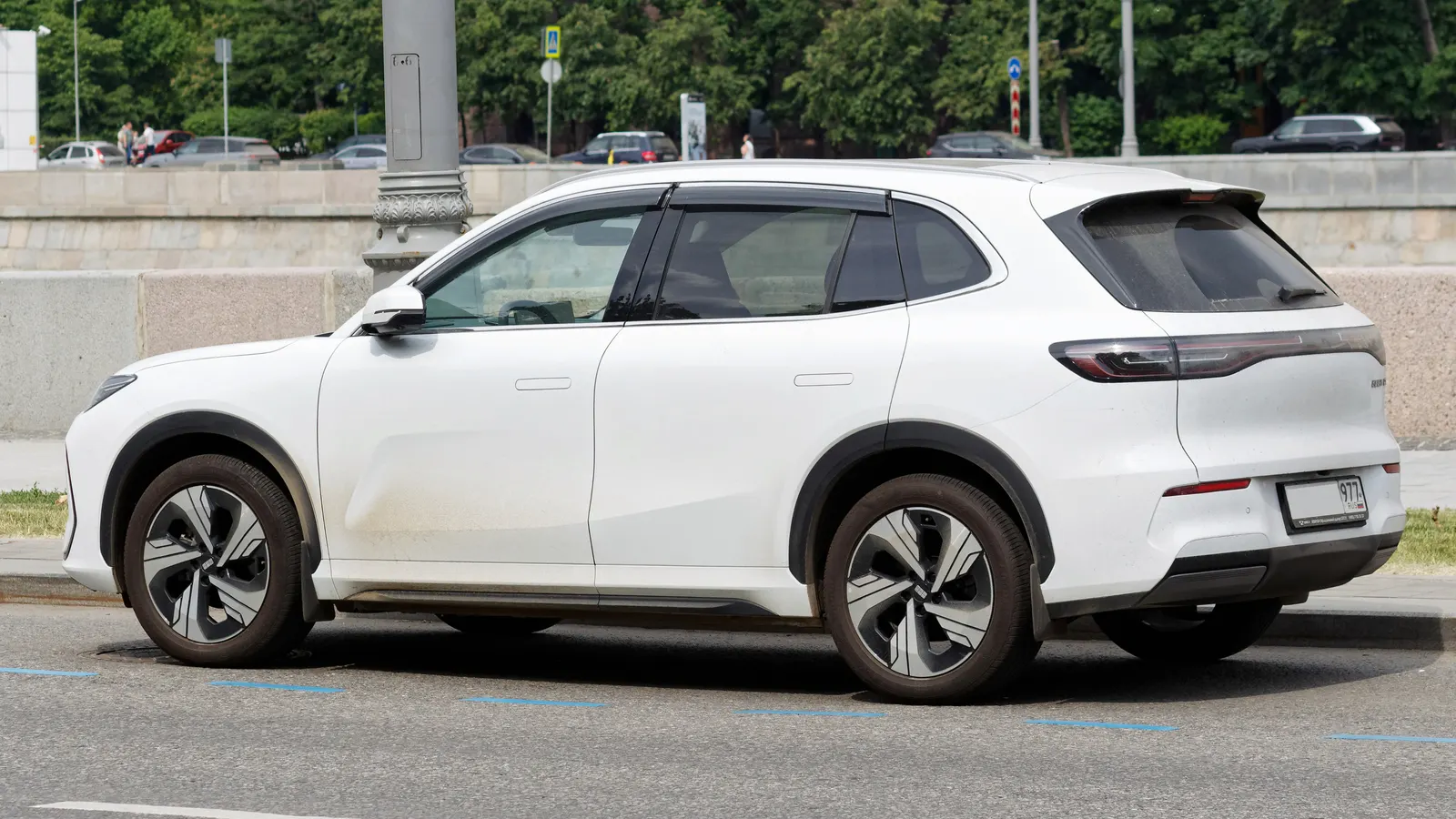 Geely EX5 compact electric SUV in white, rear three-quarter view, parked on a street in Moscow