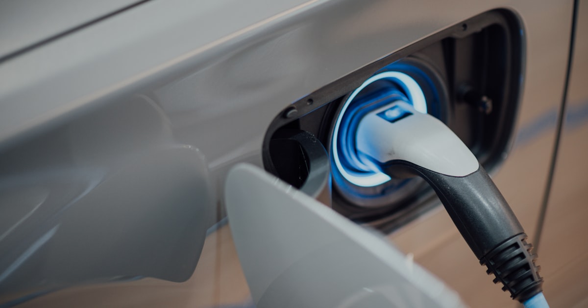 Electric vehicle plugged into a home charging station at night
