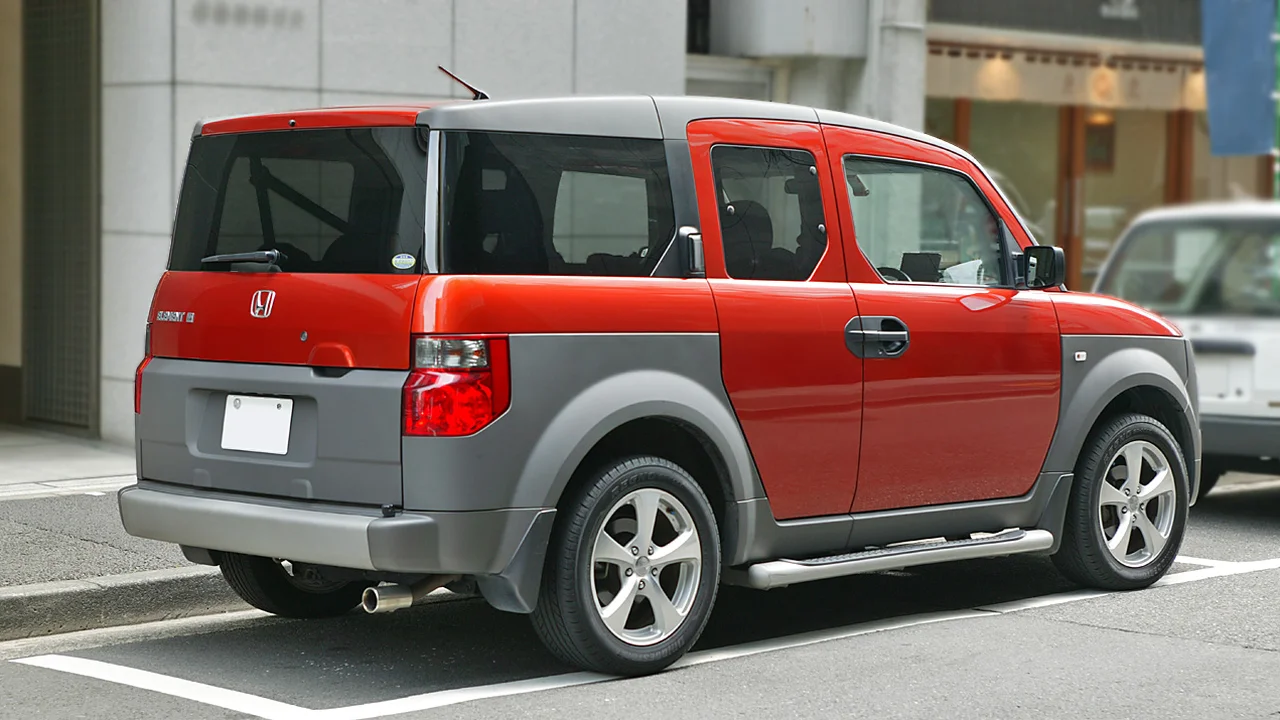 Original Honda Element (2003&ndash;2011) in red, rear three-quarter view, showing the boxy, function-first rear design the revived nameplate is reportedly chasing