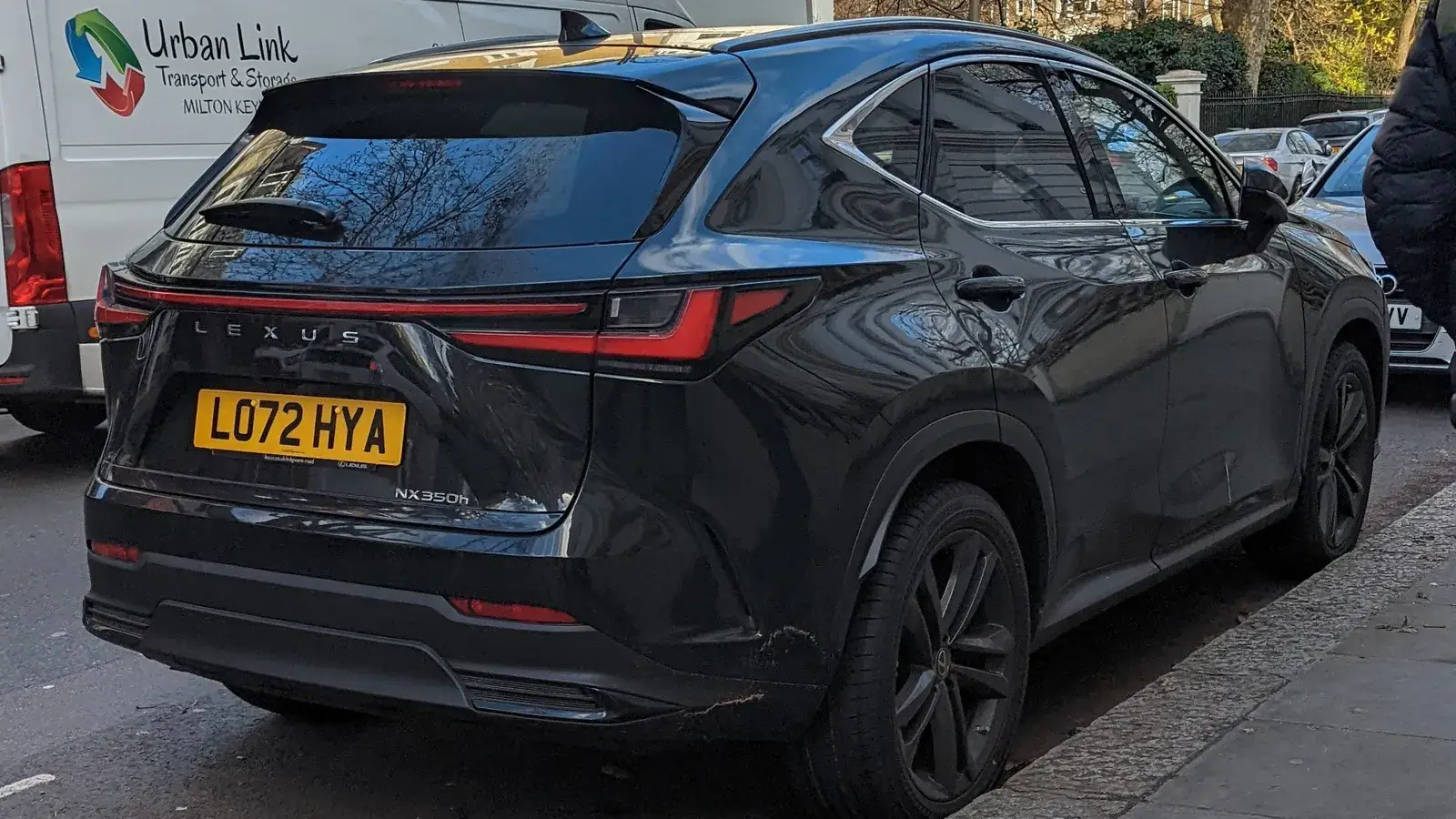 Dark grey Lexus NX 350h compact luxury SUV, rear three-quarter view parked on a city street
