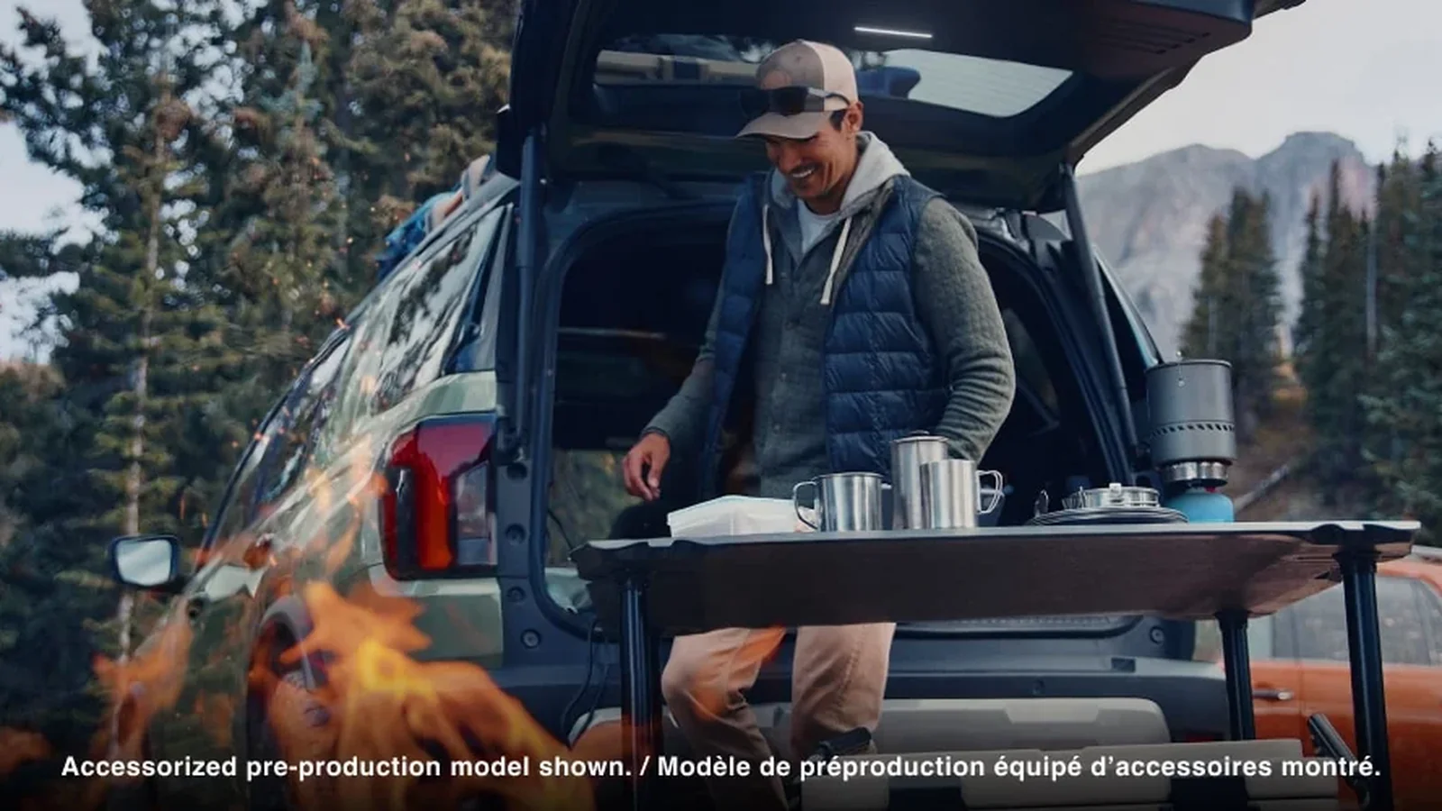 Honda Passport with the tailgate open at a mountain campsite, a camp table set up behind it (2026 accessorized pre-production model)